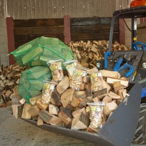 lots of logs in the bucket of a tractor